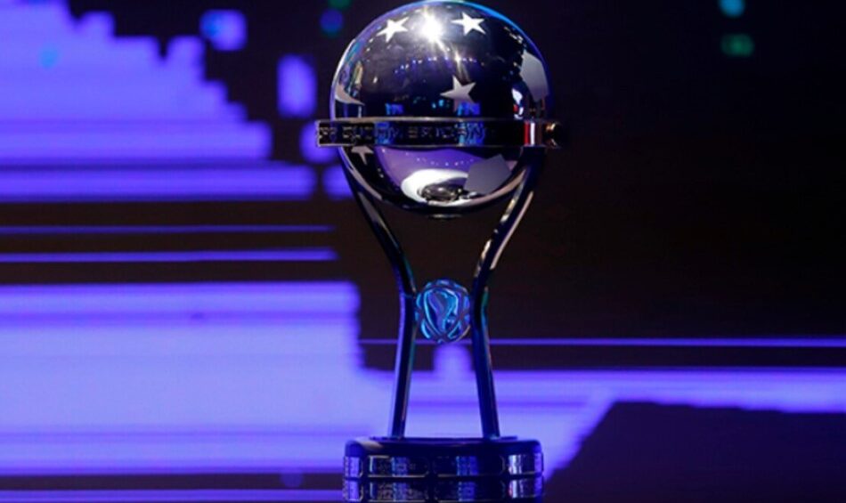 Una imagen que muestra a Paolo Guerrero celebrando con el trofeo de la Sudamericana junto al logotipo de LDU.