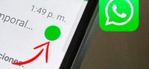 Smartphone mostrando WhatsApp con punto verde simbolizando mensajes no leídos.